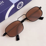 Sunglasses with brown lenses and black frames on a light surface, with a blue box in the background.