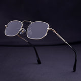 Eyeglasses with gold frame and dark lenses on a dark background