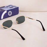 Gold-framed sunglasses with black arms on a light beige background, next to a blue box with a white logo.