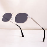 Sunglasses with black lenses and silver frames on a light beige background