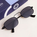 Black sunglasses with dark lenses on a white surface next to a blue box.