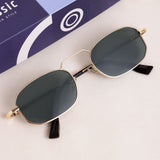 Gold-framed sunglasses with green lenses on a white surface, with a blue box in the background.