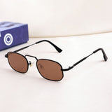 Small oval sunglasses with brown lenses on a white surface, with a blue box in the background.