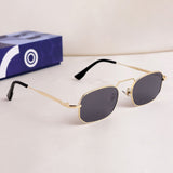 Gold-framed sunglasses with black lenses on a white surface, with a blue box in the background.