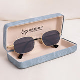 Sunglasses with gold frame and dark lenses in a blue case on a light background